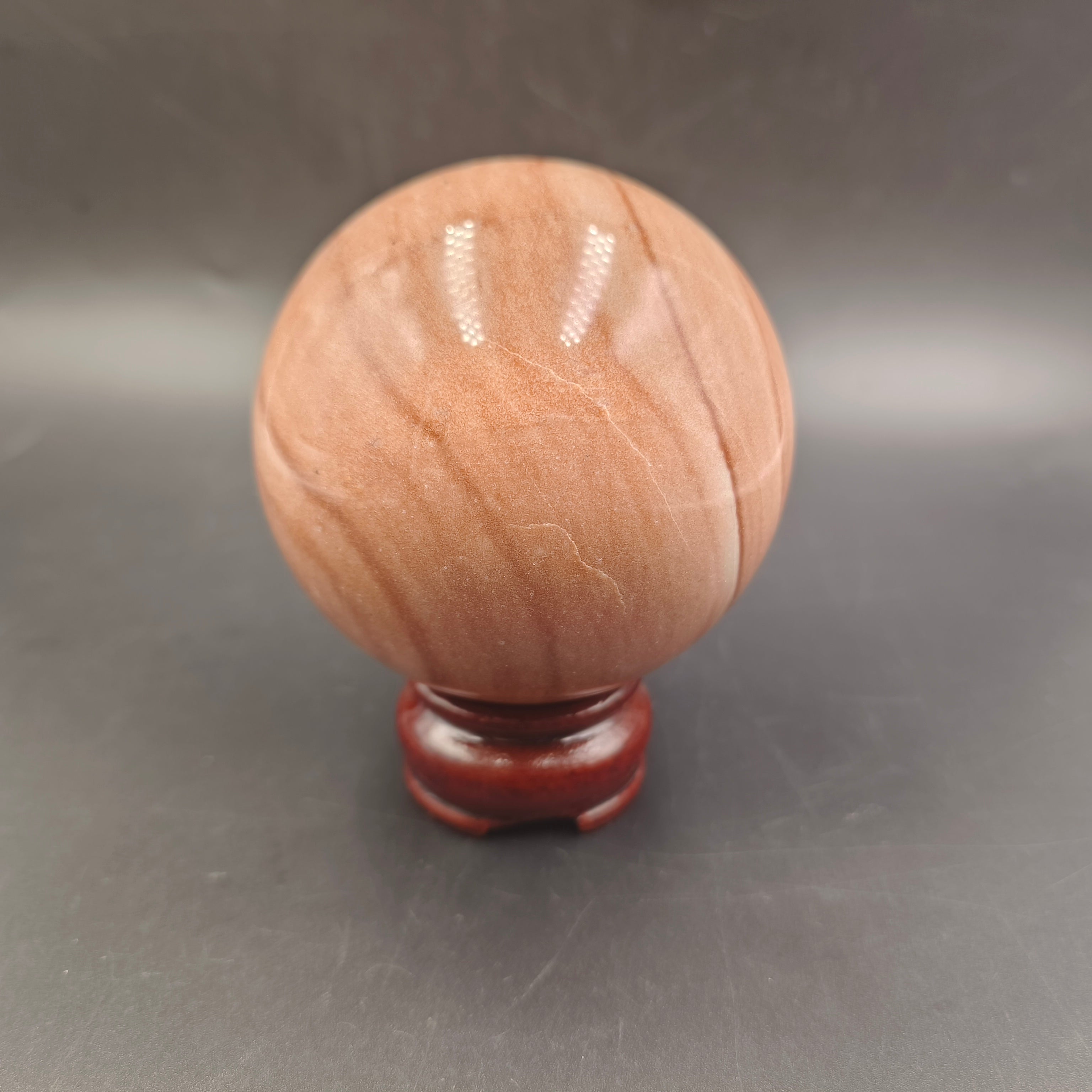 Red woodgrain stone sphere